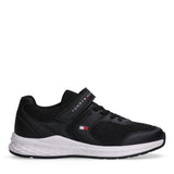 Black low-cut sneaker with mesh and synthetic upper, black laces, and a velcro strap with Tommy Hilfiger branding. White text