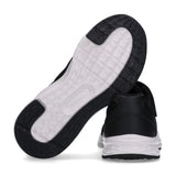 Black low-cut sneaker with mesh and synthetic upper, white wavy midsole, black outsole, and a black velcro strap.