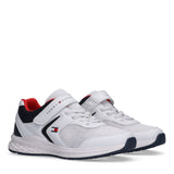 Pair of Tommy Hilfiger Kids low-cut sneakers in white and blue with red accents, featuring mesh panels and a Velcro strap.