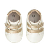 Pair of off-white low-cut sneakers with two gold-toned velcro straps, one with "TOMMY HILFIGER" logo, gold-toned heel collar,