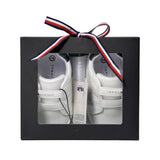 Pair of white low-cut sneakers with two velcro straps each, blue ankle trim, and "TOMMY" branding on insoles and sides.