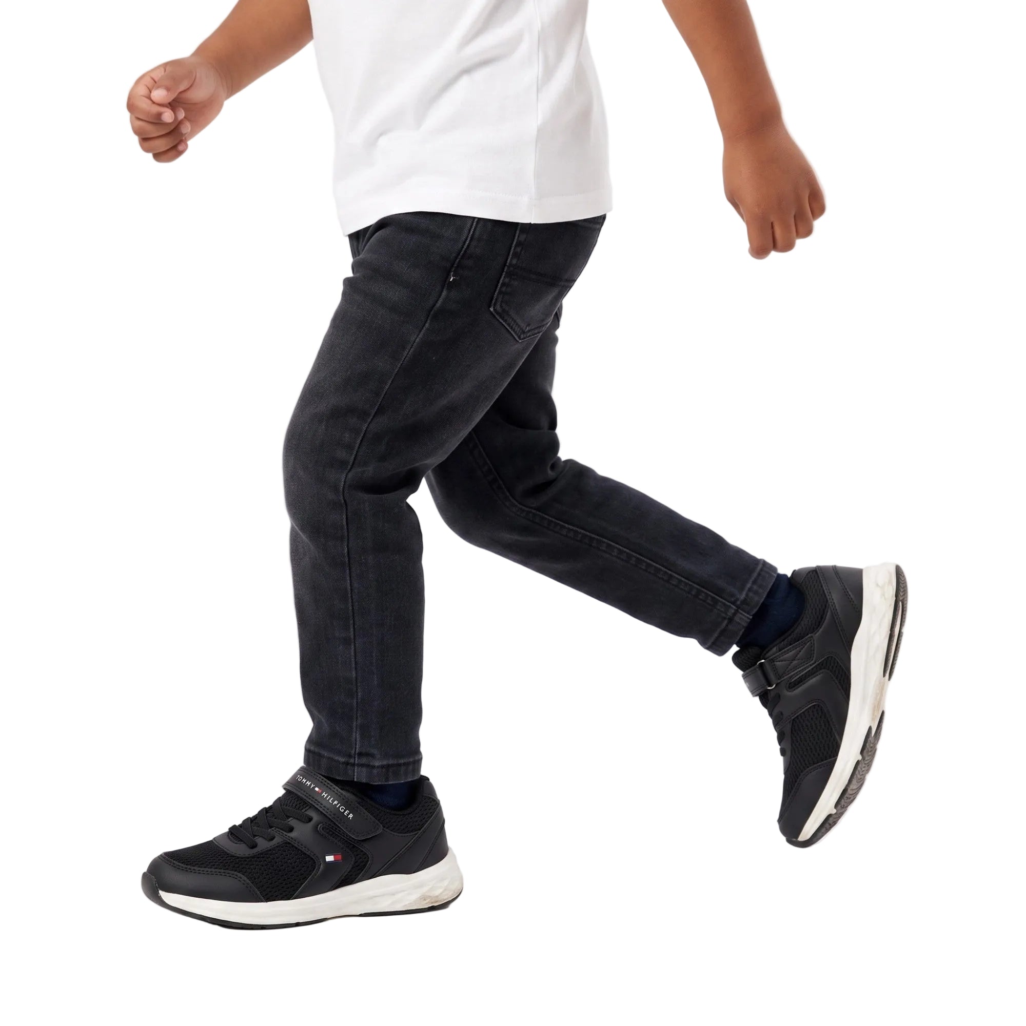 A child wearing the black sneakers walking.