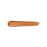 A smooth, slightly glossy swatch of medium brown concealer, rounded at one end and feathered at the other.