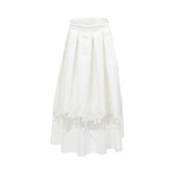 Front view of the Tuba Ergin off-white pleated maxi skirt against a white background, displaying deep top-pleats and a wide, sheer horizontal band near the hemline filled with ornate guipure lace patterns.