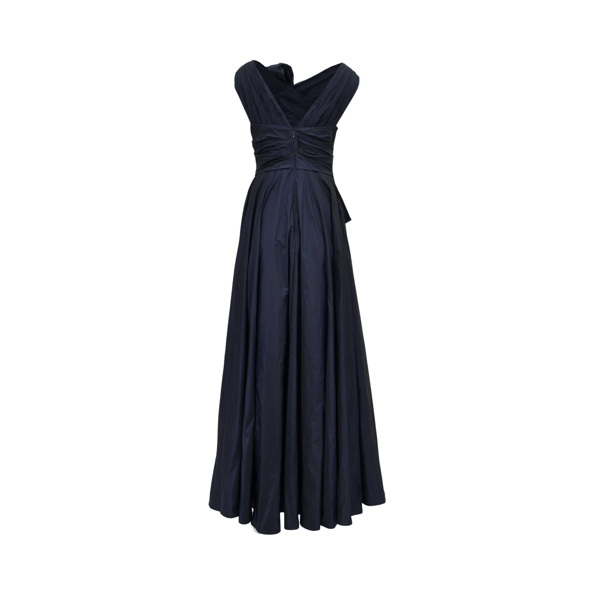 Back view of a TALBOT RUNHOF navy gown showing the elegant V-shaped back, structured pleating at the waist, and the expansive floor-length hem.