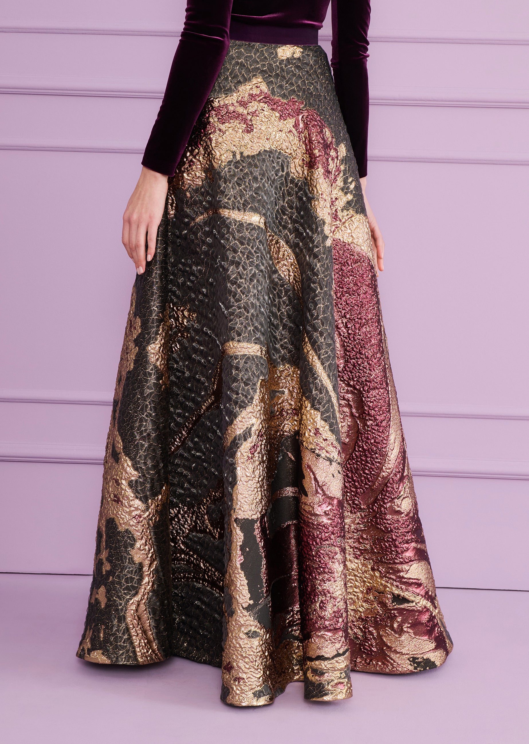 Long A-line skirt in dark fabric with raised, textured metallic bronze-toned and deep red abstract patterns.