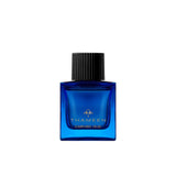 A 50ml square vibrant blue glass bottle of Thameen Carved Oud featuring gold lettering and topped with a textured black cylindrical cap.