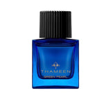 A 100ml square vibrant blue glass bottle of Thameen Green Pearl featuring gold lettering and topped with a textured black cylindrical cap.