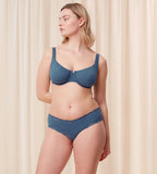 Third model full front view of the Triumph Natural Spotlight blue hipster panty, showing the low-rise fit and flat lace detailing at the legs. Shop Now Online