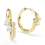 A three-quarter perspective studio view of the Swarovski Mesmera hoop earrings, highlighting the asymmetric layering of the marquise and pear-shaped crystals against the gold-plated frames.