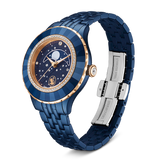 A three-quarter studio shot of the Swarovski Octea Moon watch over a black background, showcasing the curve of the blue-finish metal bracelet, the open stainless steel deployment clasp, and the warm rose gold-tone casing accents.