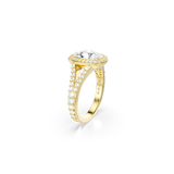A dynamic three-quarter perspective shot of the Swarovski Una Angelic ring, illustrating the structural dimension where the main setting splits into an elegant Y-shape, lined completely with glittering clear crystals set against a warm gold backdrop.