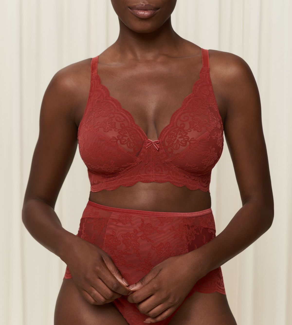 Triumph Amourette 300 Rococo non-wired bra in mannish red second model front view, showcasing the intricate floral lace and wireless cup design. Order Online Today
