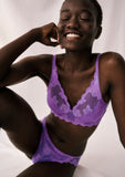 Triumph Amourette 300 Summer non-wired bra in purple model sitting down full front view, featuring unpadded floral embroidery. Available Now