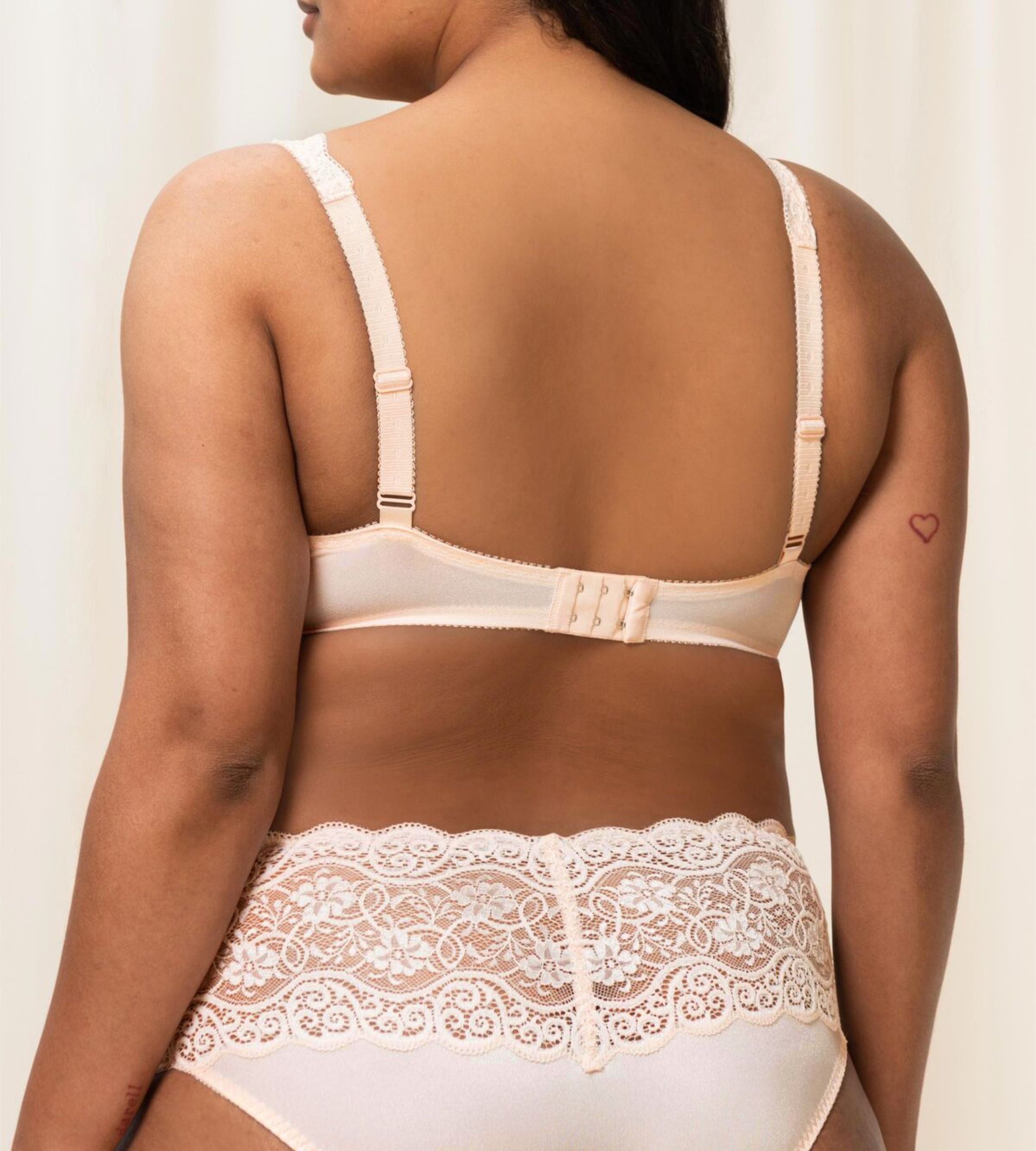 Triumph Amourette 300 wired padded bra in light beige model back view, showing adjustable straps and the floral lace overlay and smooth padded cups. Available for Online Purchase