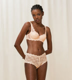 Triumph Amourette 300 wired padded bra in light beige second model full front view, showing the floral lace overlay and smooth padded cups. Available for Online Purchase