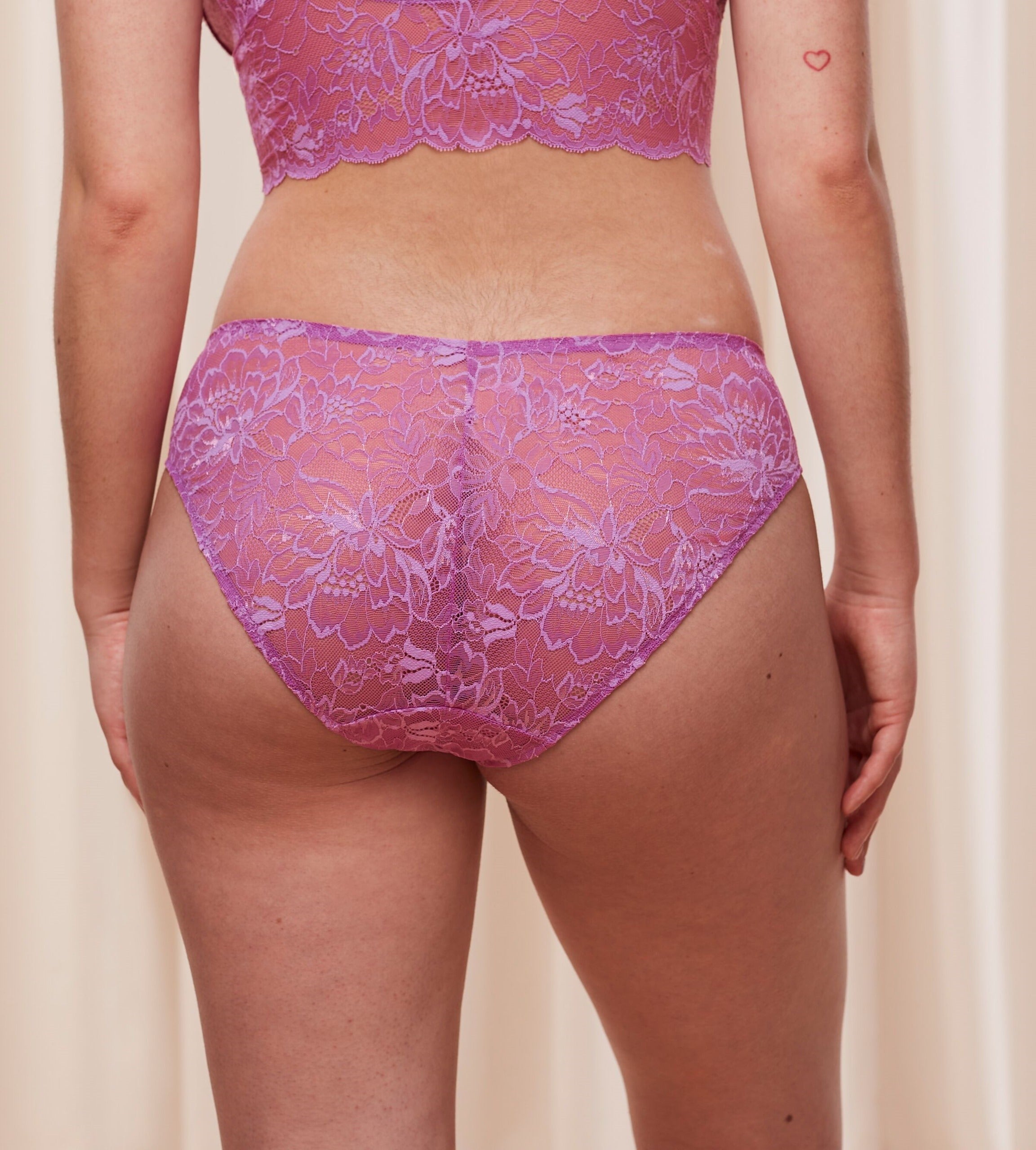 Triumph Amourette Charm Summer Tai panty in pink third model back view, highlighting the high-leg floral lace design and smooth seamless back. Shop Online at Blue Salon Qatar
