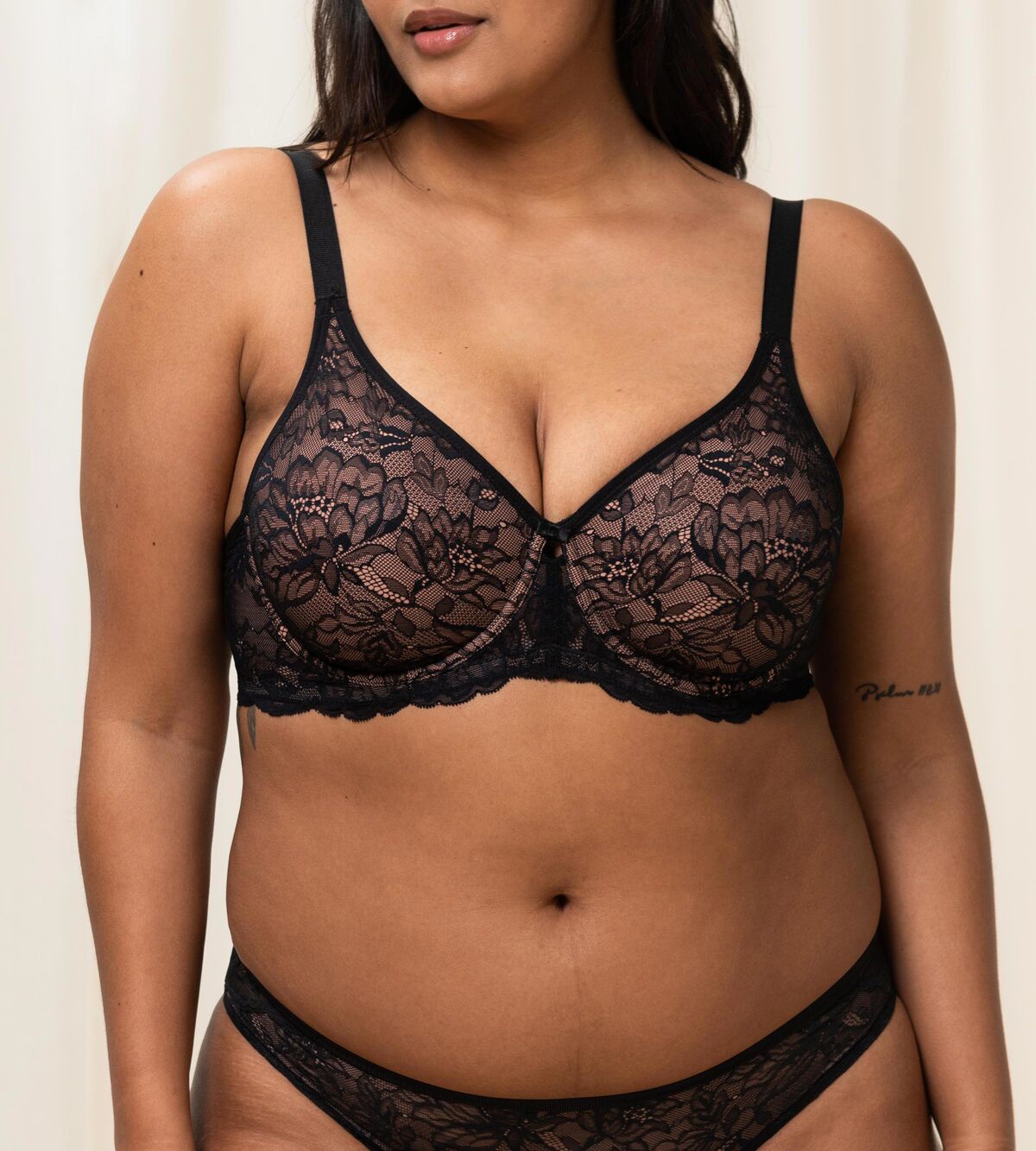 Triumph Amourette Charm black wired bra second model front view, featuring intricate floral lace cups and a supportive underwired design. Shop Now Online
