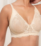 Triumph Amourette Charm non-wired bra in light beige model close-up front view, detailing the floral lace cups and plunge neckline. Available for Online Purchase