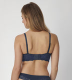 Triumph Amourette Charm non-wired bra in navy blue model back view, showcasing the floral design and adjustable straps. Find Now Online