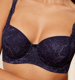 Triumph Amourette Charm wired padded bra in navy blue model close-up view, detailing the lace-covered cups and supportive underwired design. Available at Blue Salon Qatar
