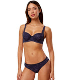 Triumph Amourette Charm wired padded bra in navy blue model full front view, showing the lace-covered cups and supportive underwired design. Available at Blue Salon Qatar