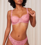 Triumph Amourette Charm wired padded bra in pink model front view, showcasing the lace-covered cups and supportive underwired design. Order Online Today