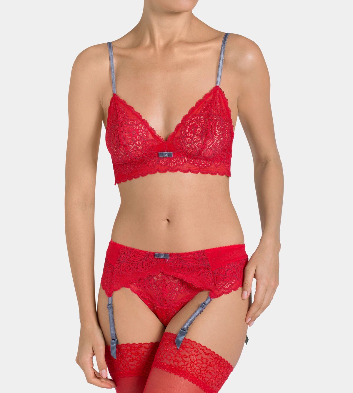 Triumph Amourette Spotlight garter belt in red model front view, featuring graphical floral lace and four adjustable suspender straps. Now Available Online