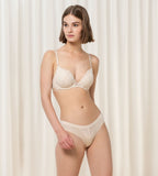 Triumph Aura Spotlight light beige wired push-up bra second model full front view, showing the lace-overlaid padded cups and design. Available Online Today.