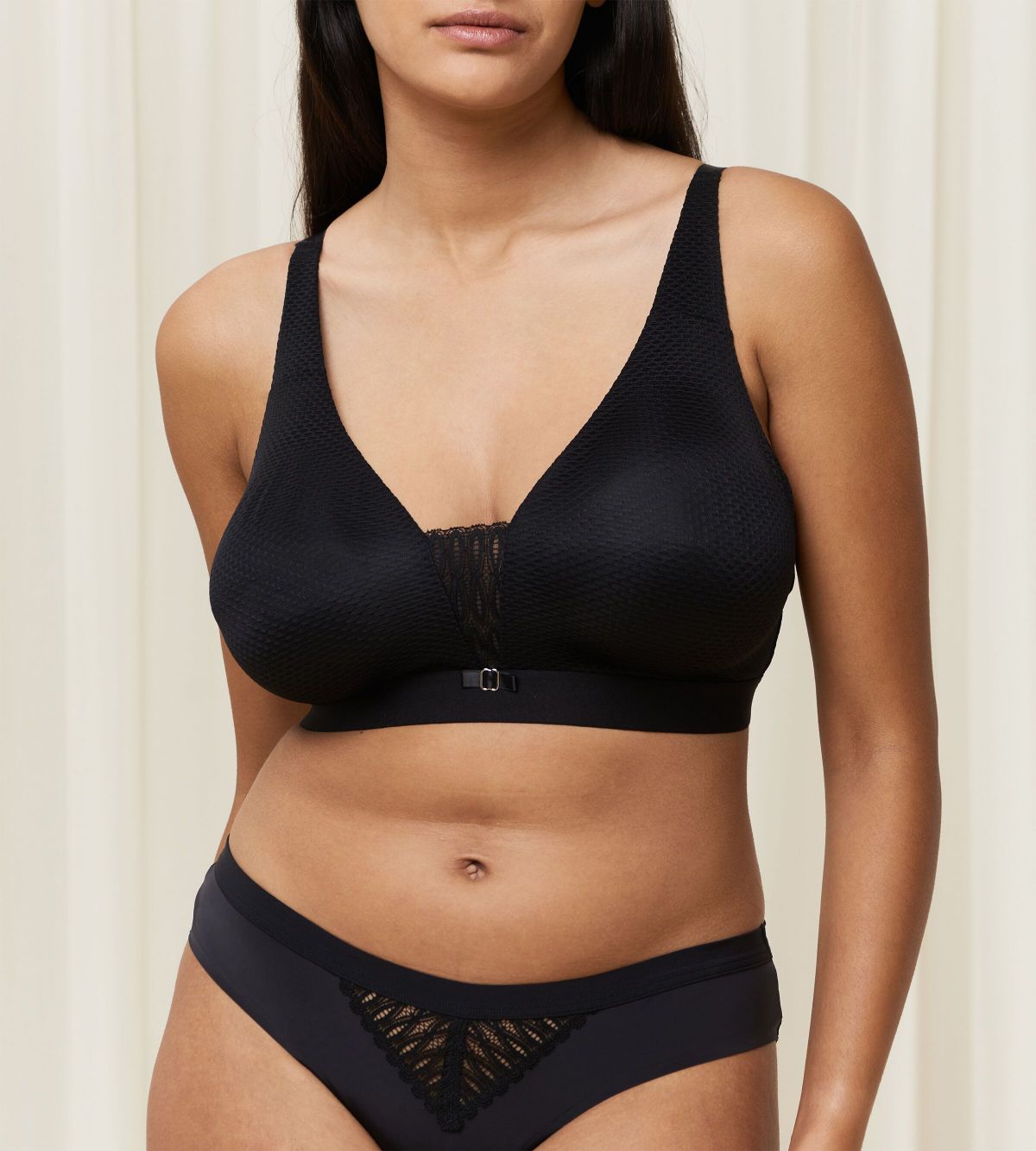 Triumph Aura Spotlight non-wired bra in black model front view, highlighting the plunging lace neckline and comfortable wireless design. Find Now Online