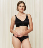 Triumph Aura Spotlight non-wired bra in black third model full front view, showing the plunging lace neckline and comfortable wireless design. Find Now Online