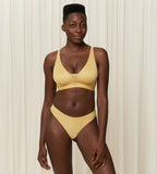 Triumph Aura Spotlight non-wired bra in yellow model full front view, showcasing the vibrant floral lace and supportive wireless design. Shop the Latest Online