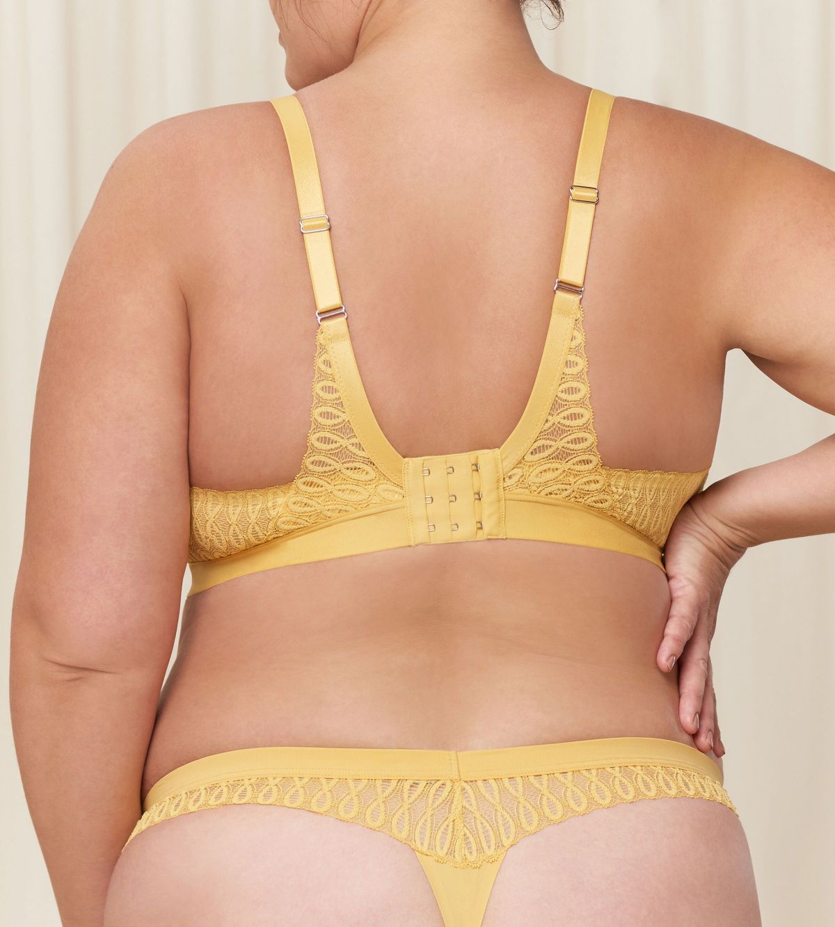 Triumph Aura Spotlight non-wired bra in yellow third model back view, showcasing adjustable straps with the vibrant floral lace and supportive wireless design. Shop the Latest Online