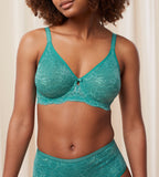 Triumph Aura Spotlight wired bra in green third model front view, showcasing the graphic lace cups and supportive underwired design. Shop Online Today