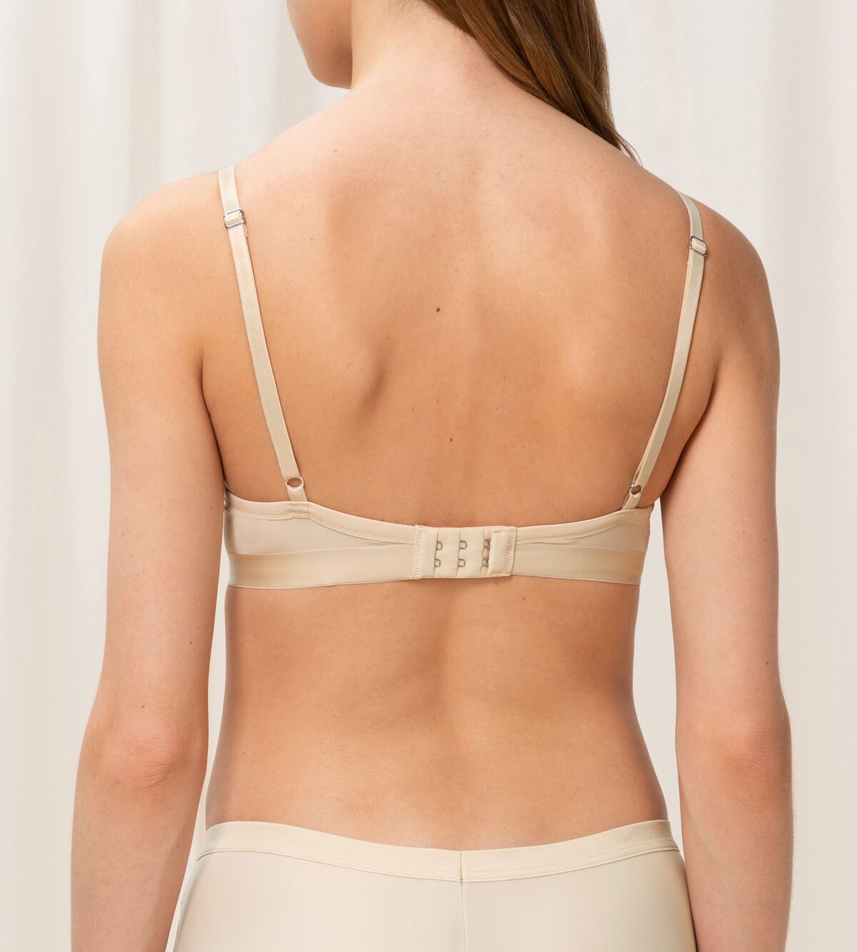 Triumph Aura Spotlight wired padded bra in light beige model back view, showing the adjustable straps. Shop Now Online