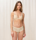 Triumph Aura Spotlight wired padded bra in light beige model full front view, showing the lace-overlaid cups and comfortable underwired design. Shop Now Online