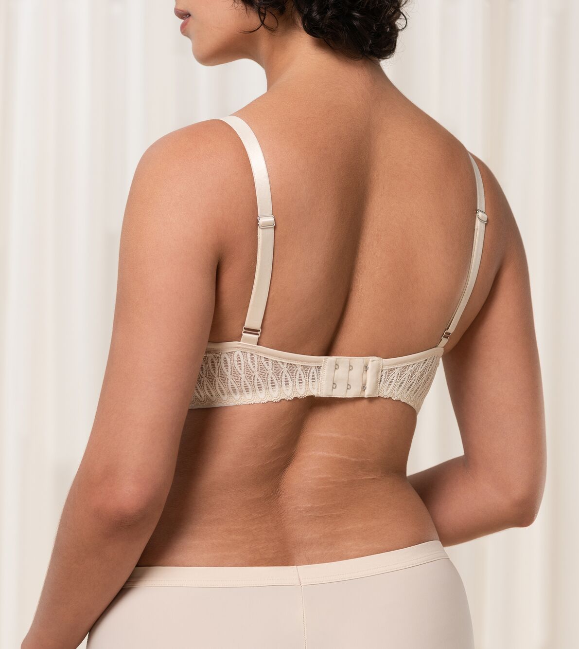 Triumph Aura Spotlight wired padded bra in light beige second model back view, showing adjustable straps. Available Online