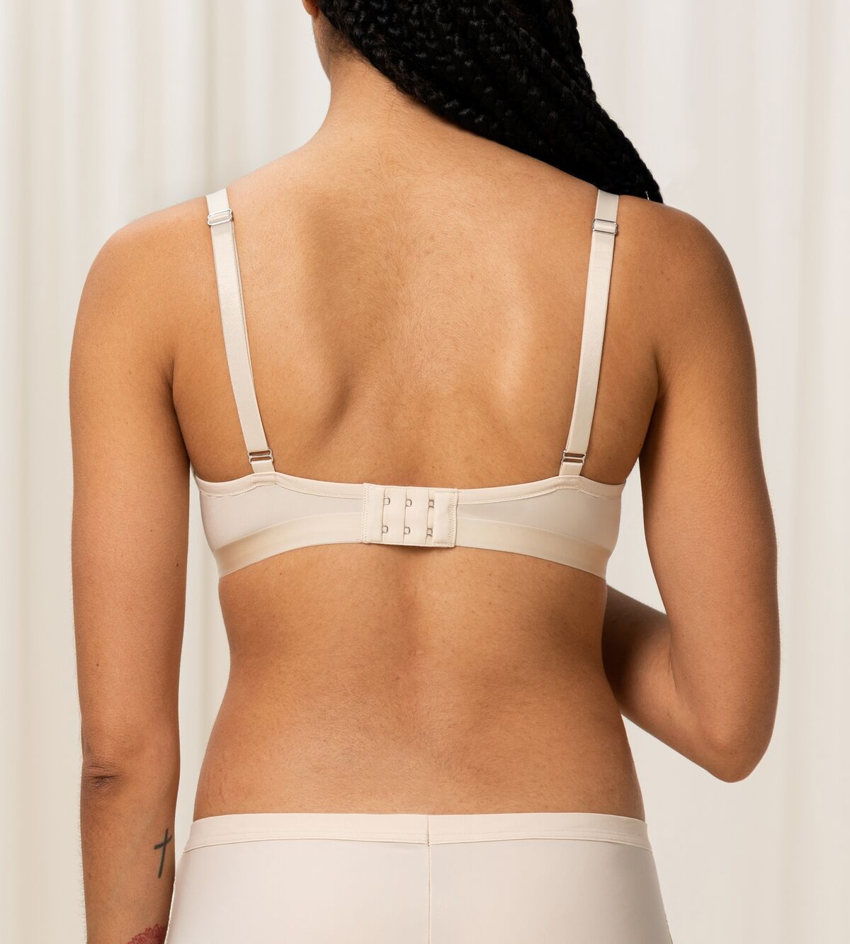 Triumph Aura Spotlight wired padded bra in light beige third model back view, showing the adjustable straps. Shop Now Online