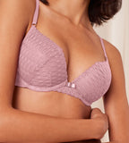 Triumph Aura Spotlight wired push-up bra in vibrant pink model close-up view, detailing the padded lace cups and a modern graphic design. Available for Online Purchase
