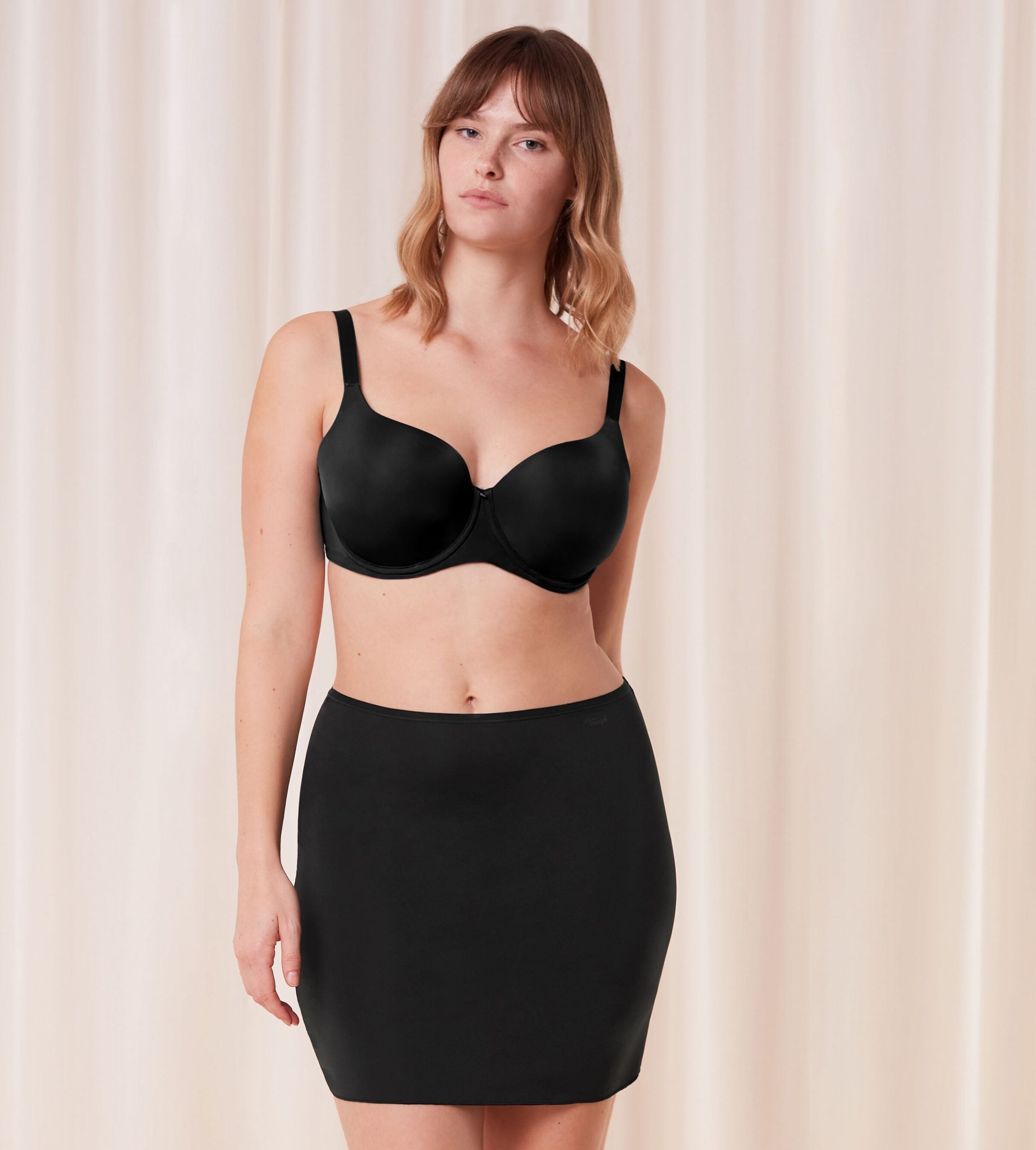 Triumph Body Make-Up black slip skirt model full front view, showing the smooth microfiber fabric and seamless laser-cut hem. Shop the Latest Online