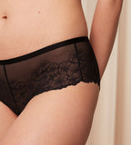 Triumph Bright Spotlight black hipster panty model close-up view, showcasing the intricate floral lace design. Order Online at Blue Salon Qatar