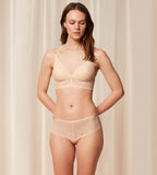 Triumph Bright Spotlight light beige hipster panty model full front view, highlighting the floral lace pattern and flat-processed edges. Shop Now Online