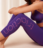 Triumph Cardio RTW high waist purple sports leggings model sitting down view, highlighting the triaction, showing the supportive waistband and sleek performance fabric. Available for Online Purchase