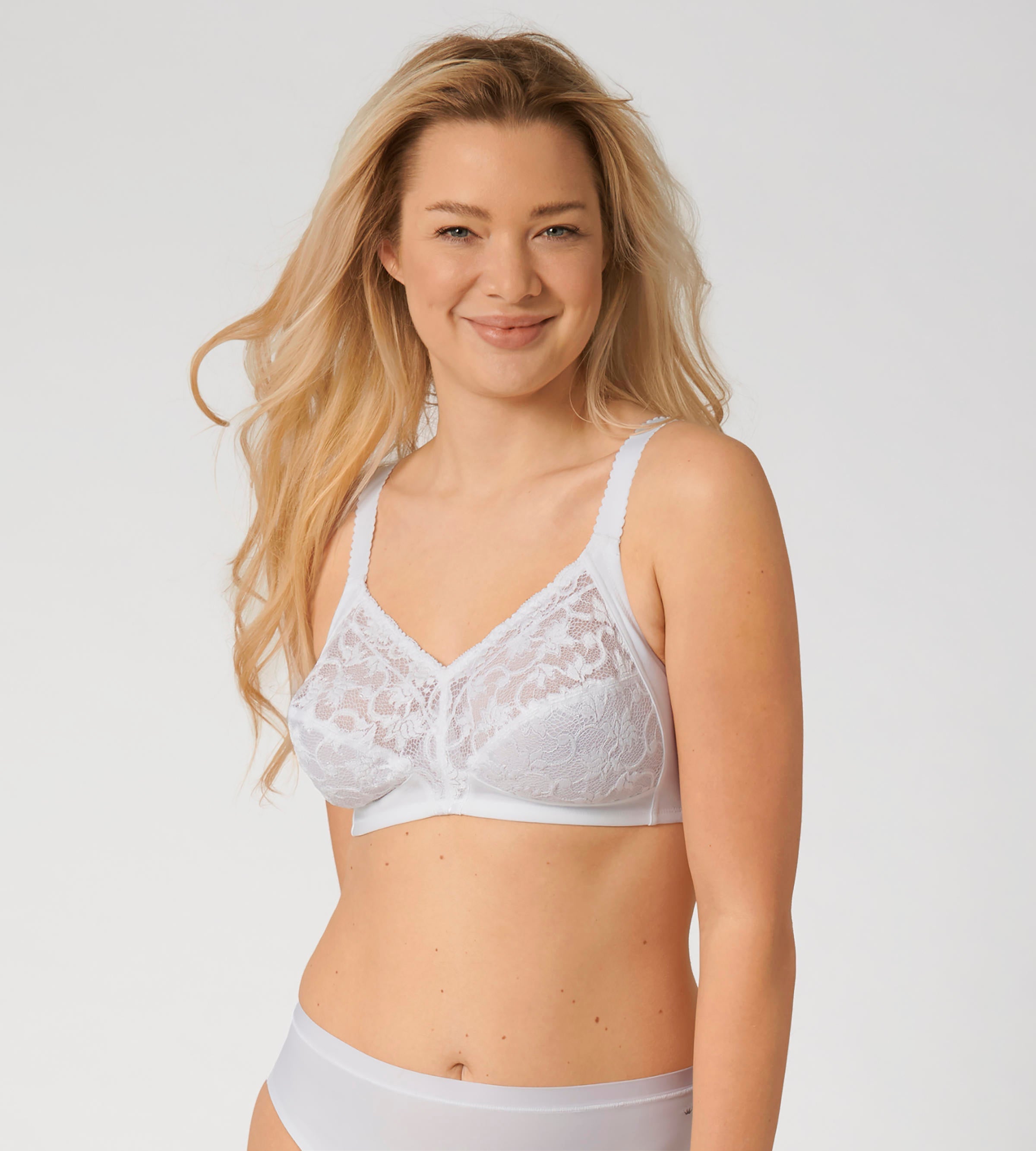 Triumph Delicate Doreen white non-wired bra model front view, highlighting the intricate lace cups and supportive wide straps. Available Now Online