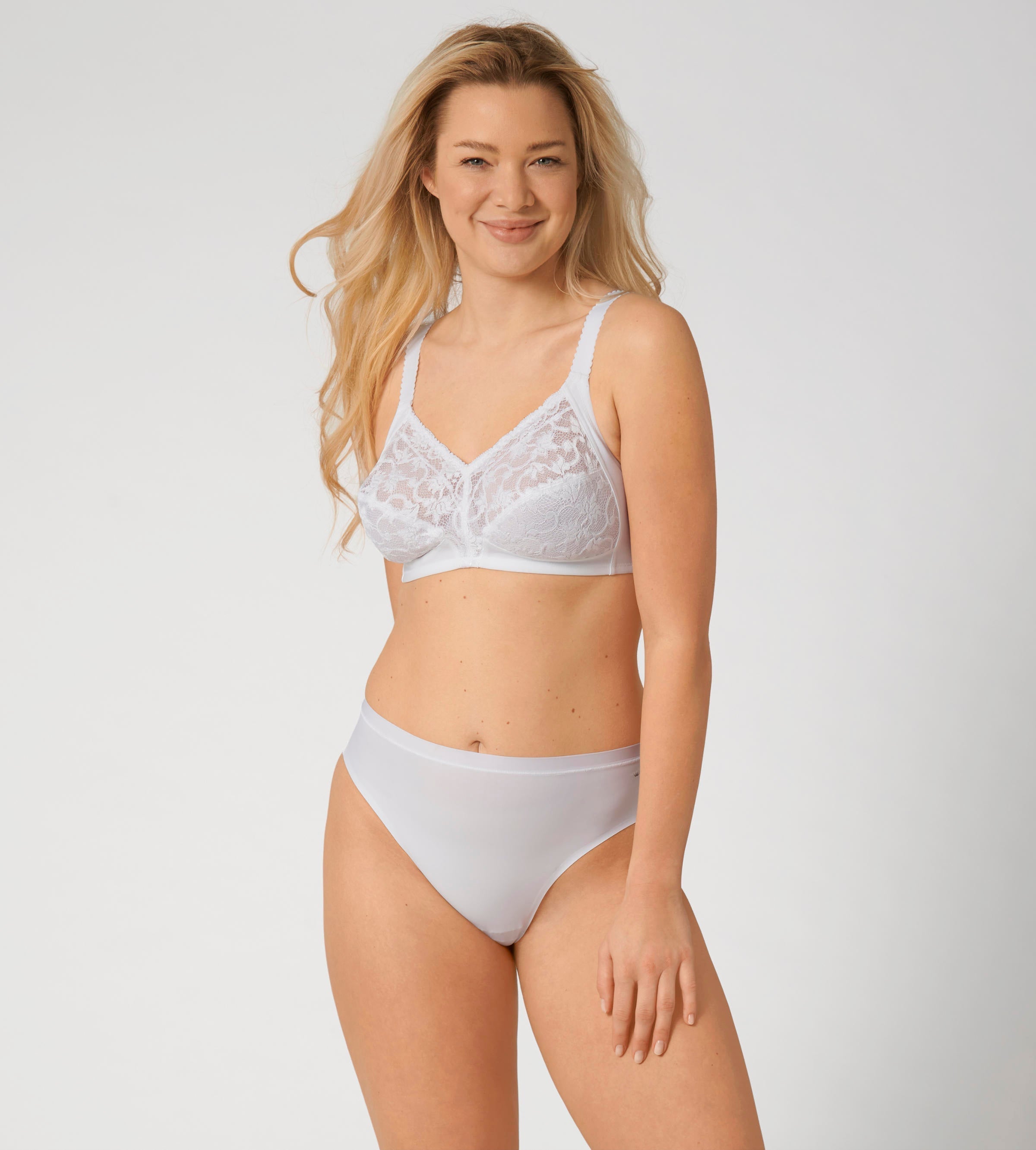 Triumph Delicate Doreen white non-wired bra model full front view, highlighting the intricate lace cups and supportive wide straps. Available Now Online