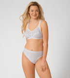 Triumph Delicate Doreen white non-wired bra model full front view, highlighting the intricate lace cups and supportive wide straps. Available Now Online