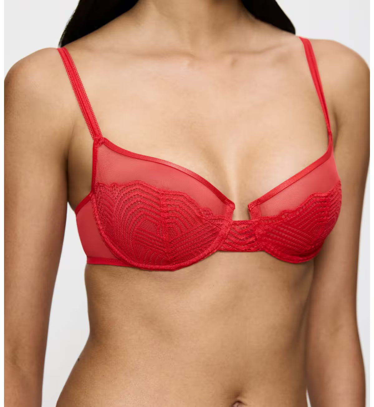 Triumph Delightful Spotlight red wired bra model close-up front view, detailing the intricate graphic lace and feminine balcony silhouette. Shop Online Today