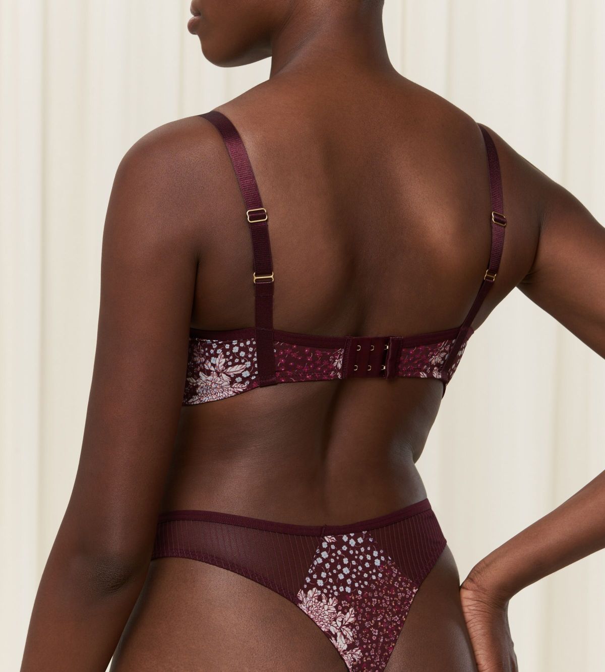 Triumph Lavish Spotlight burgundy wired padded bra second model back view, highlighting the detailed lace embroidery and the adjustable straps with back closure. Now Online at Blue Salon Qatar