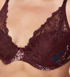 Triumph Lavish Spotlight burgundy wired padded bra third model close-up view, highlighting the detailed lace embroidery and elegant plunge fit. Now Online at Blue Salon Qatar