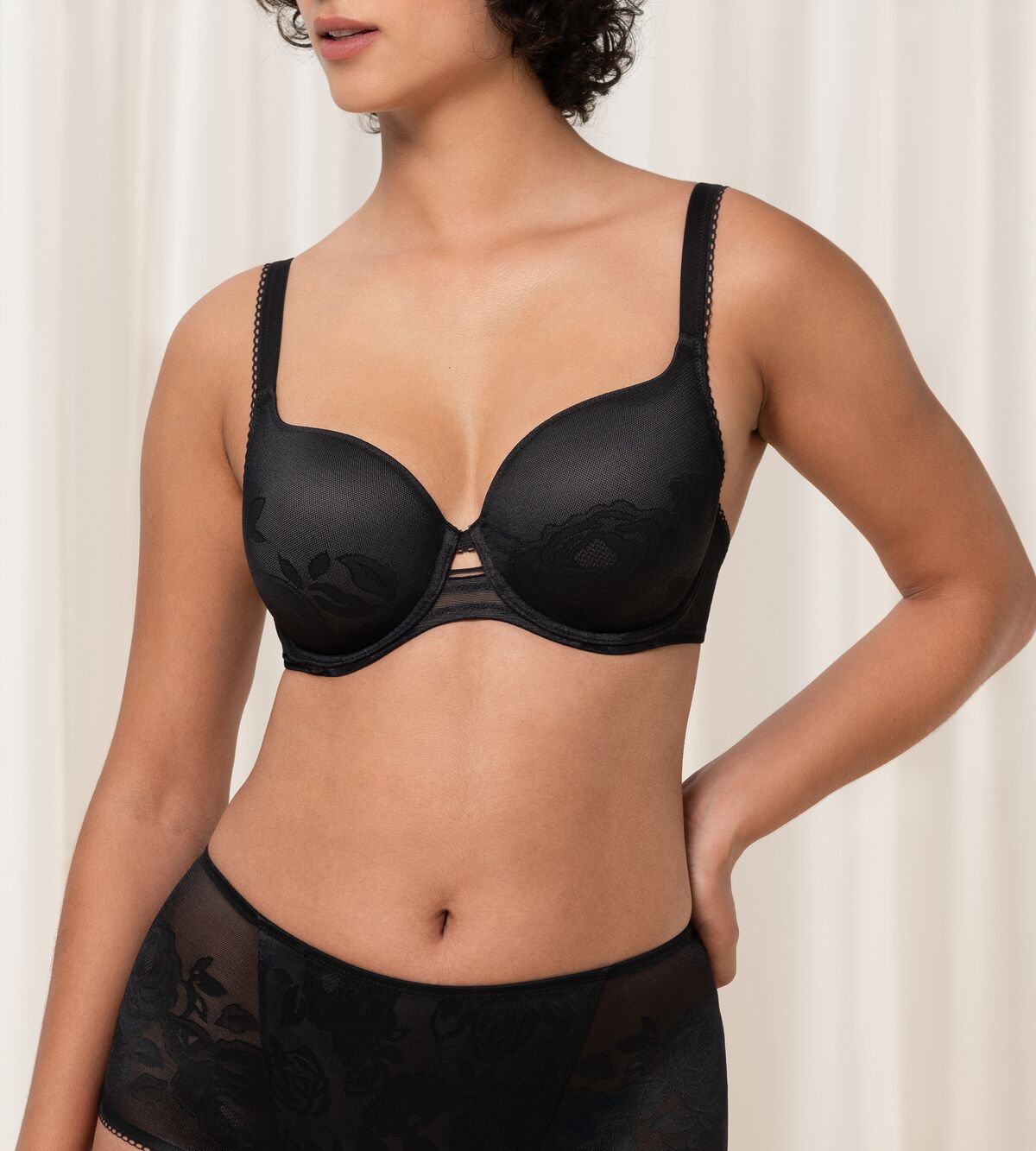 Triumph Wild Rose Sensation black padded wired bra third front model view, featuring floral lace detailing. Find Online Now.